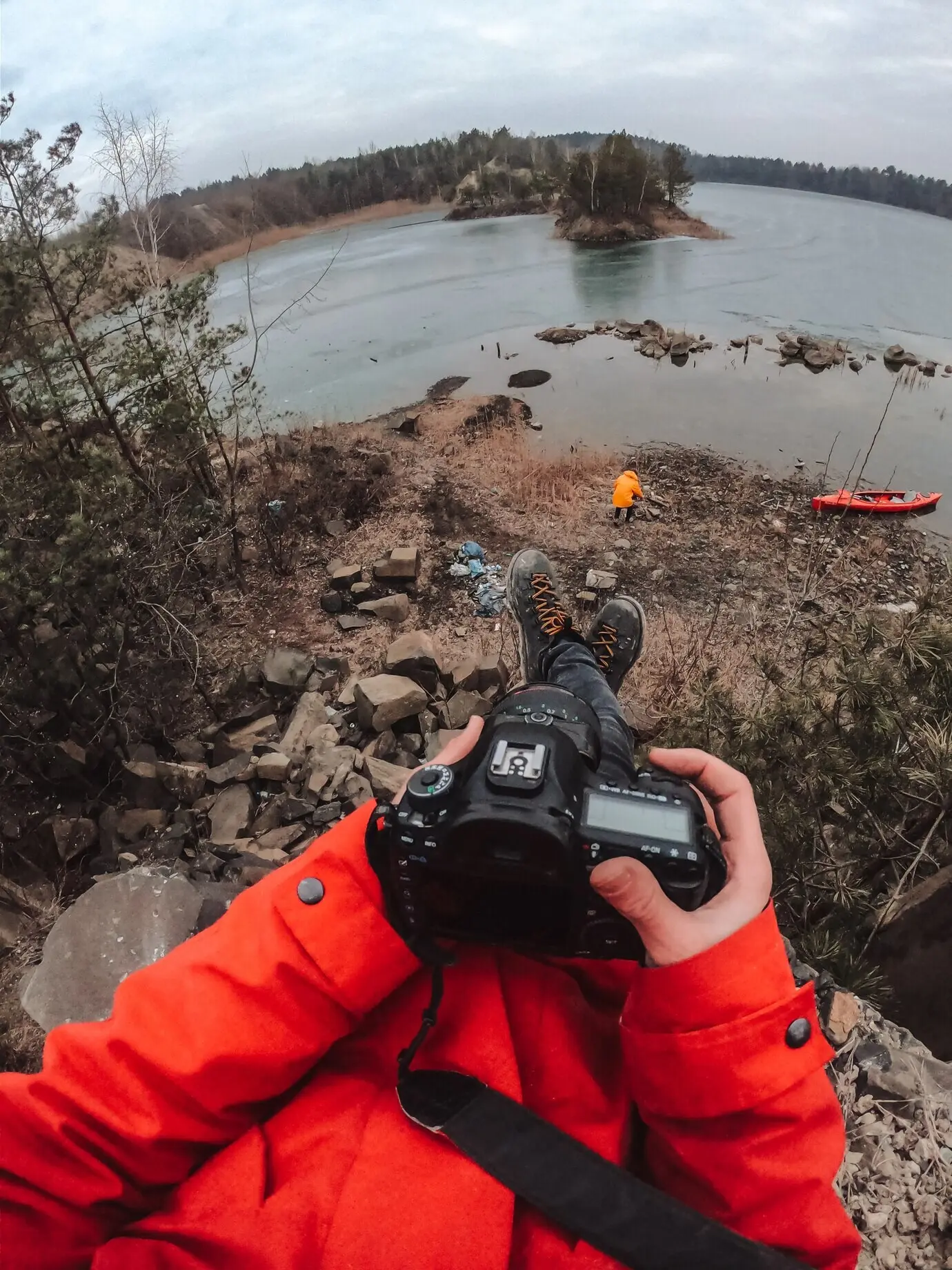 Der Typ steht am zugefrorenen See.